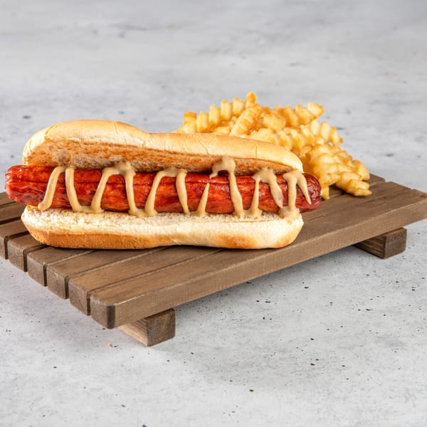 A Stewart's Drive-In hot dog with mustard and crinkle-cut fries on a wooden tray.