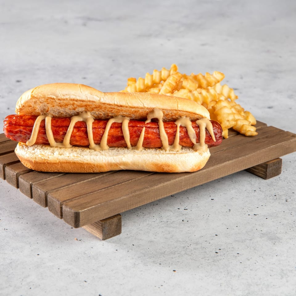 A Stewart's Drive-In hot dog with mustard and crinkle-cut fries on a wooden tray.